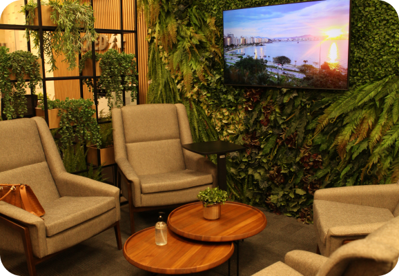 Ambiente de atendimento da Unicred com poltronas e jardim vertical